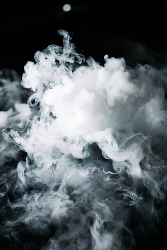 Abstract photography of swirling white smoke on a dark background, capturing ethereal beauty.